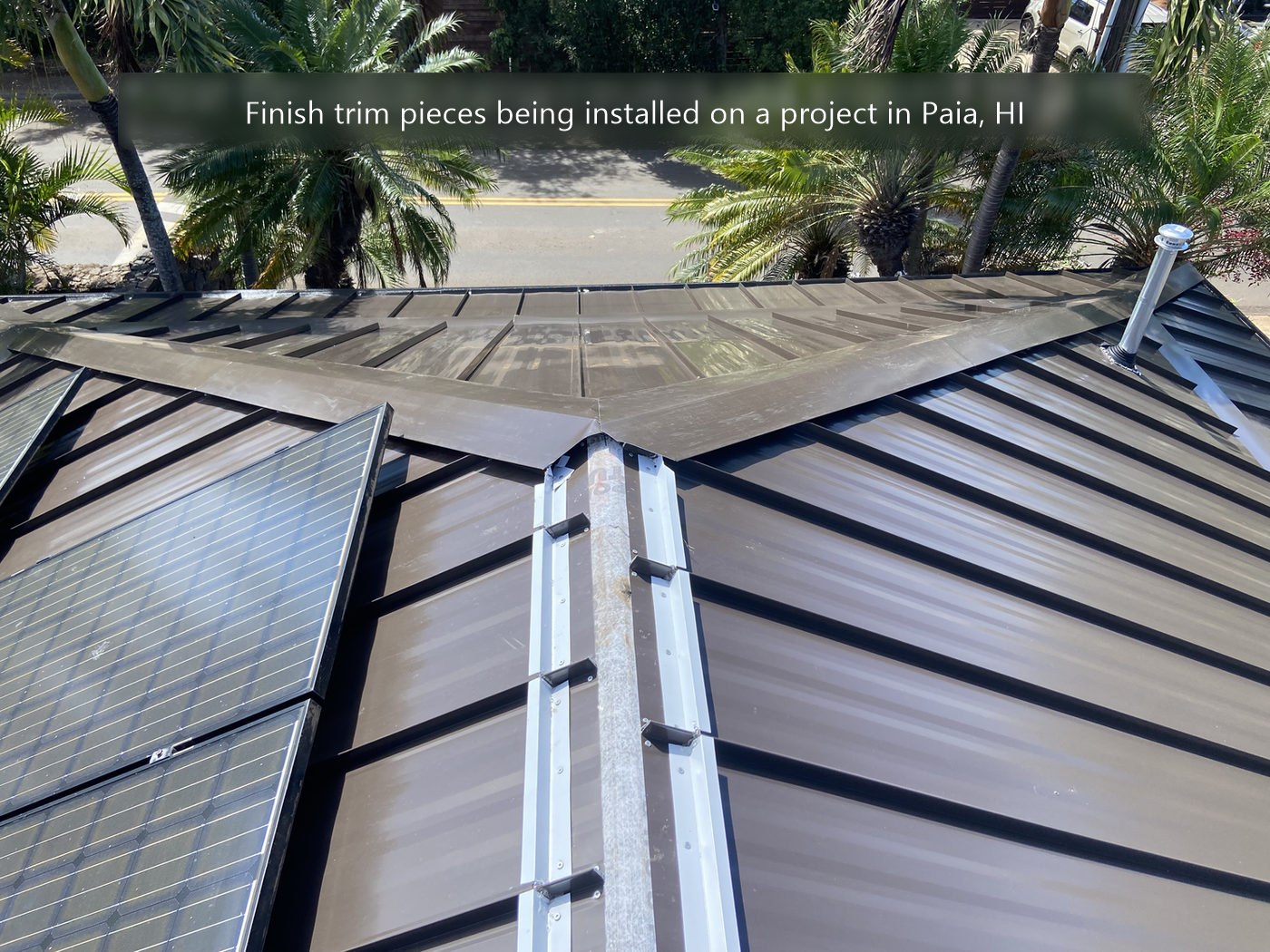 Finish trim pieces being installed on a standing seam roof in Paia